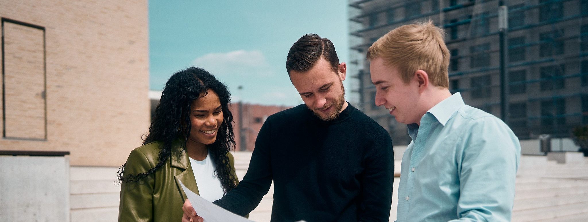 Drei junge Mitarbeitende im Gespräch bei der gemeinsamen Planung eines Projekts im Unternehmen MP Next planport.